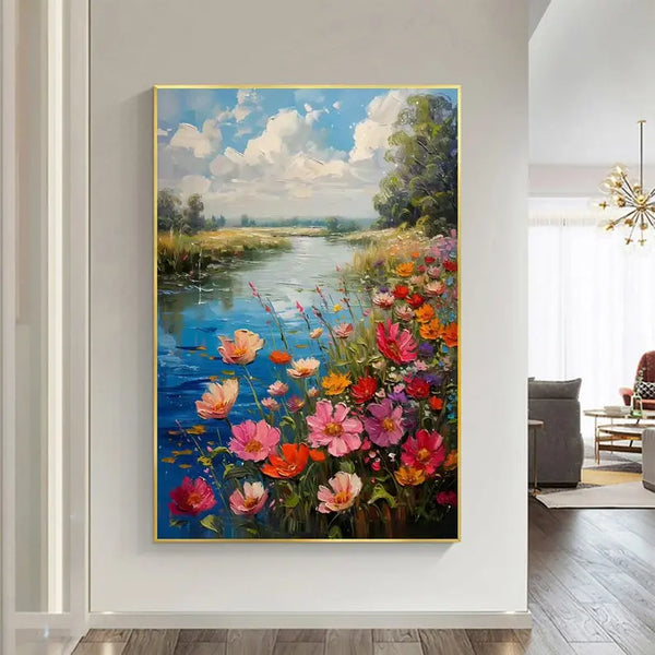 A large vertical textured painting of a blue river flowing lined by a field of flowers in pink, red, blue and orange, and green trees, beneath the blue sky with white clouds. 