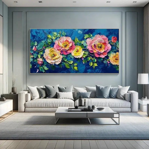 A large horizontal painting of pink and yellow peonies growing on a branch with green leaves, against a blue backdrop.