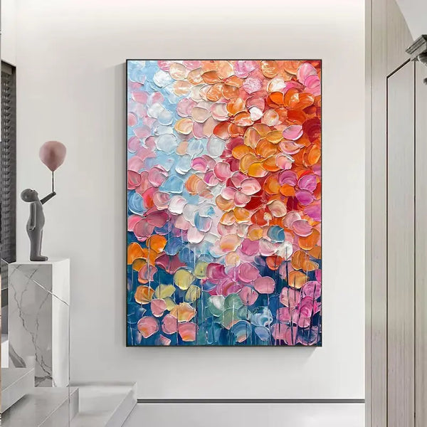 A large textured colorful painting of flower petals in pink, orange and blue