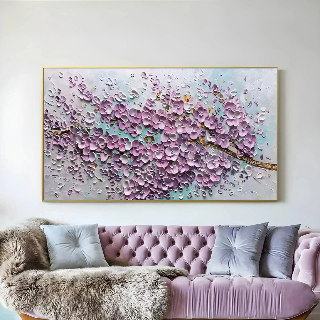 A horizontal abstract painting of lots of blossoms in pink against a white and blue backdrop 