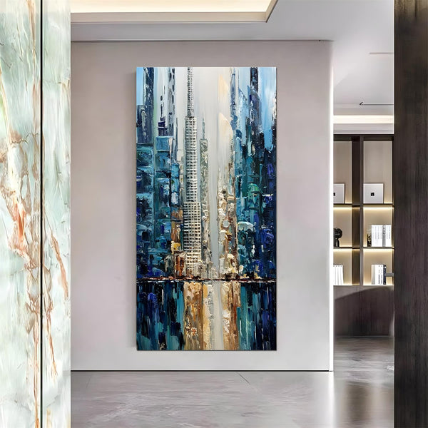 A large vertical abstract painting of blue skyscrapers dominating the grey and white skyline, with their shadows reflected on the surface in blue and yellow. 