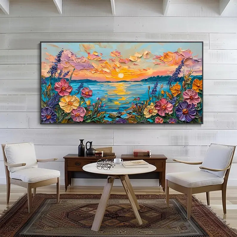 A large horizontal painting of blooming flowers in pink, orange and purple framing the sea, which reflects the orange sunset-lit sky. 
