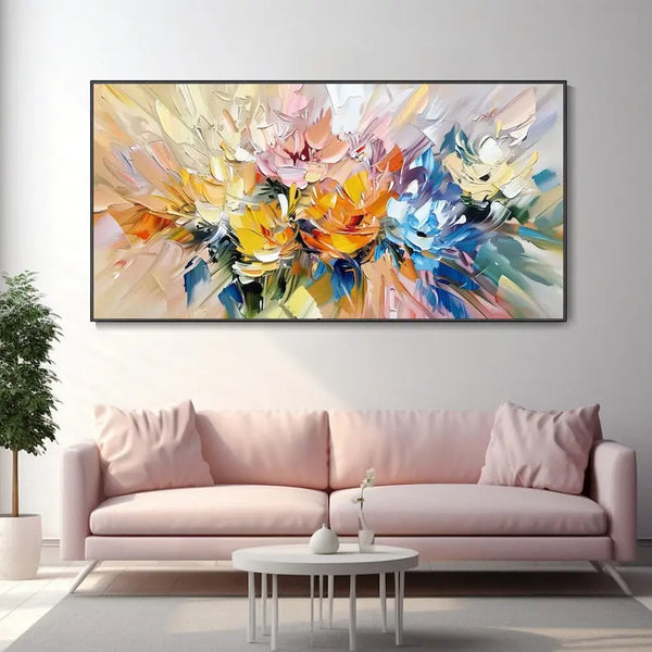 A large horizontal plastered wall art of abstract flowers in yellow, pink, orange and blue against a backdrop of beige and blue. 
