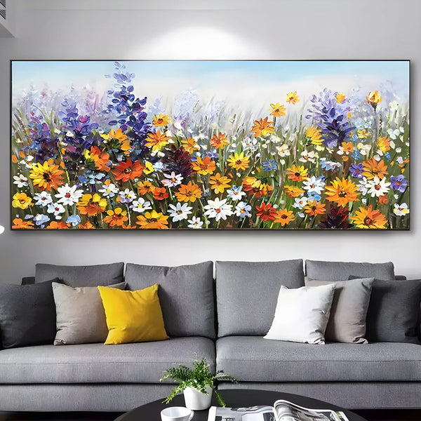 A large horizontal textured painting of flowers in yellow, orange, white and purple amidst green grass. 