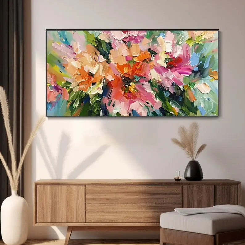 A large horizontal textured wall art of abstract flowers in pink and orange with green leaves