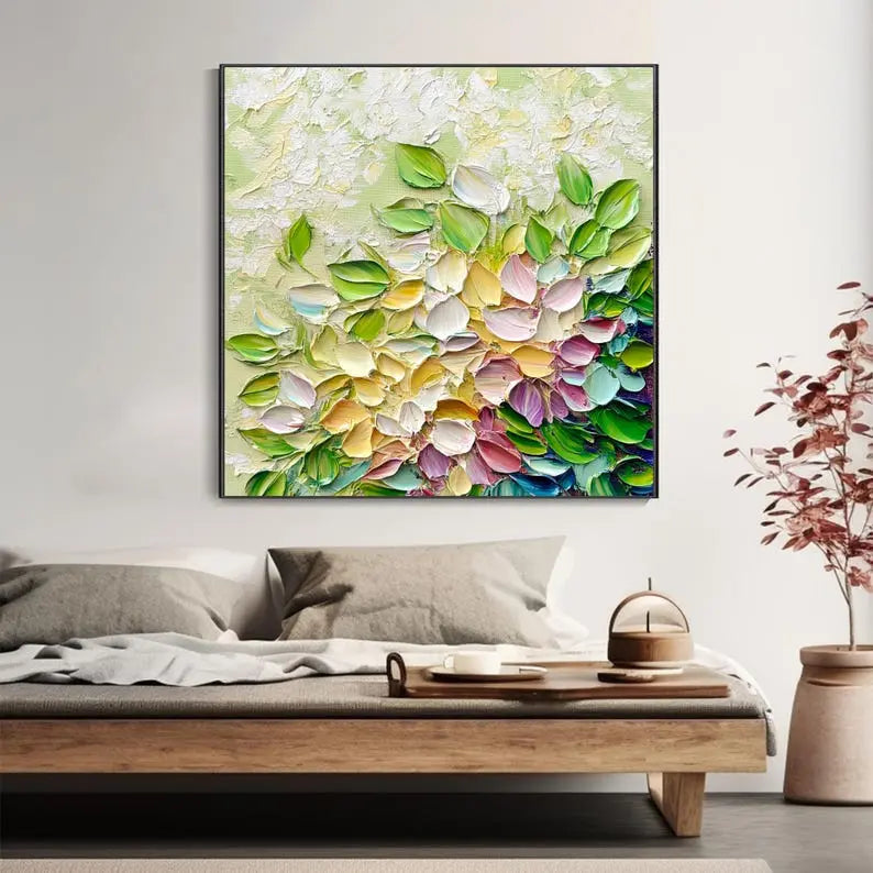 A large square textured painting of green, pink and yellow flower petals in rich acrylic texture, against a light green backdrop.