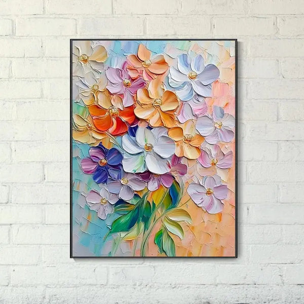 A large textured plaster wall art of blooming flowers in pink, white, blue, orange, with some green leaves against a blue and orange backdrop. 
