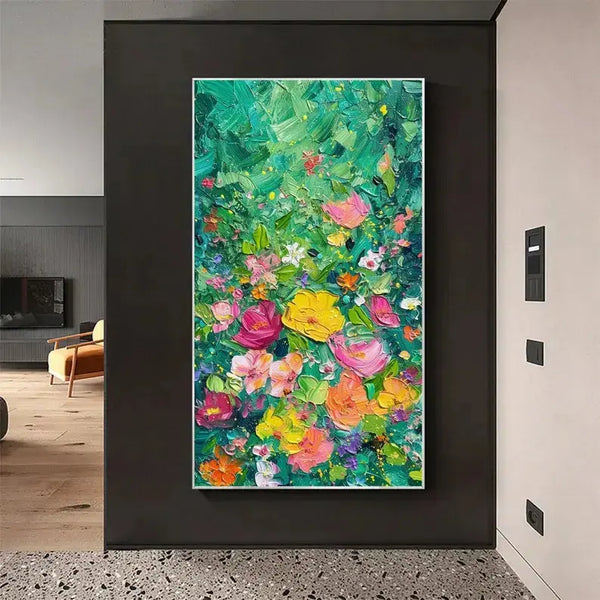 A large vertical plastered painting of flowers in a variety of colors including yellow, pink, orange and purple against a green backdrop.

