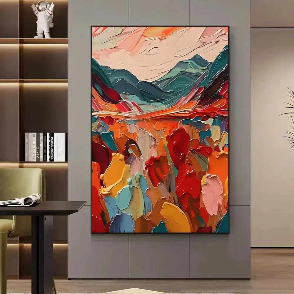 A large vertical textured painting of blooming abstract flowers in red, orange, pink, blue and green hues, and blue mountains under pink sky on the horizon. 
