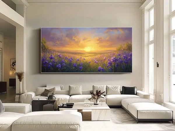 A textured horizontal wall art featuring an expansive field of purple flowers amidst green grass, beneath the sunset-lit sky with light purple clouds. 
