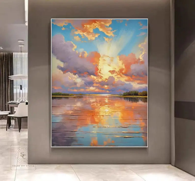 A vertical abstract wall painting of a cloudy blue and white sky with a beautiful orange-toned sun rays reflection on the ocean. 