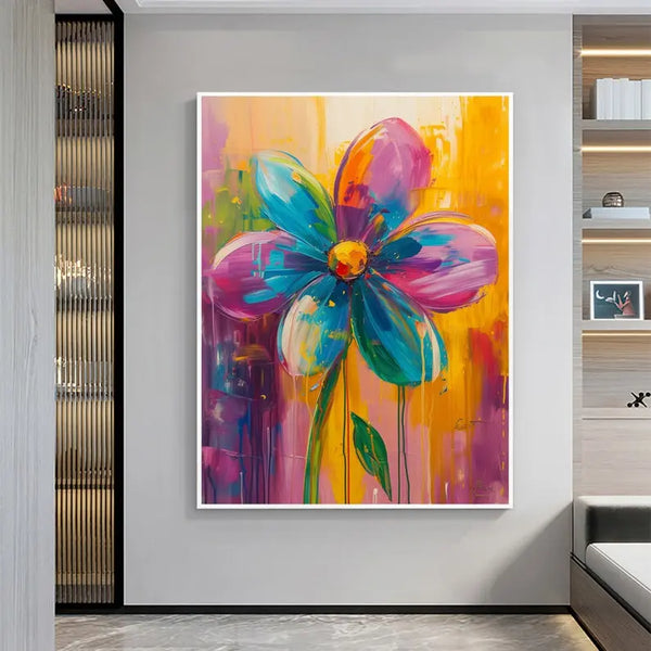 A vertical floral wall art of a large flower with 5 petals, three in pink, 3 in blue, with green stems, against a backdrop of orange and pink. 