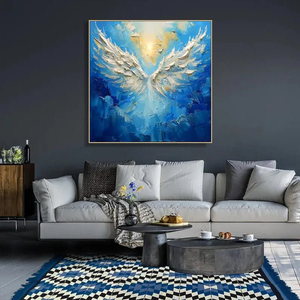 Abstract painting of large white angel wings set against rich blue skies, with a golden sun symbolizing the angel's head in mid-flight.