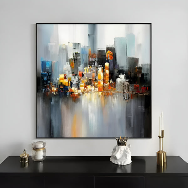 A large square painting of a cluster of highrises of varying heights near and reflected on the water.