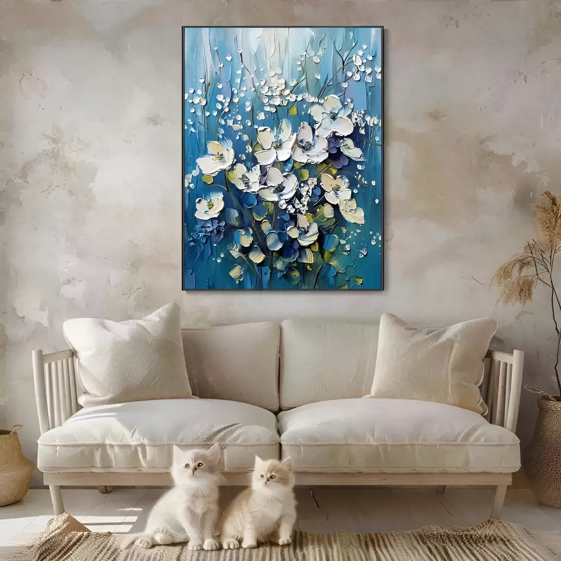 A large vertical abstract textured painting of white blossoms against a blue backdrop. 