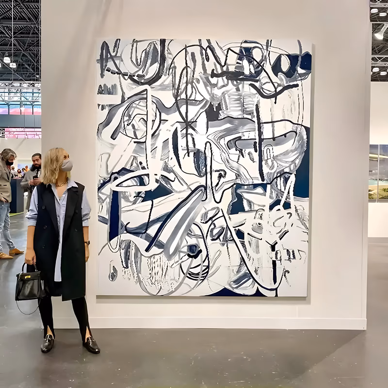 a large vertical abstract painting of big looping black and navy lines drawn over a white ground, with gray brush smears, small ovals and scattered dark blocks between the loops, in loose brushed acrylic