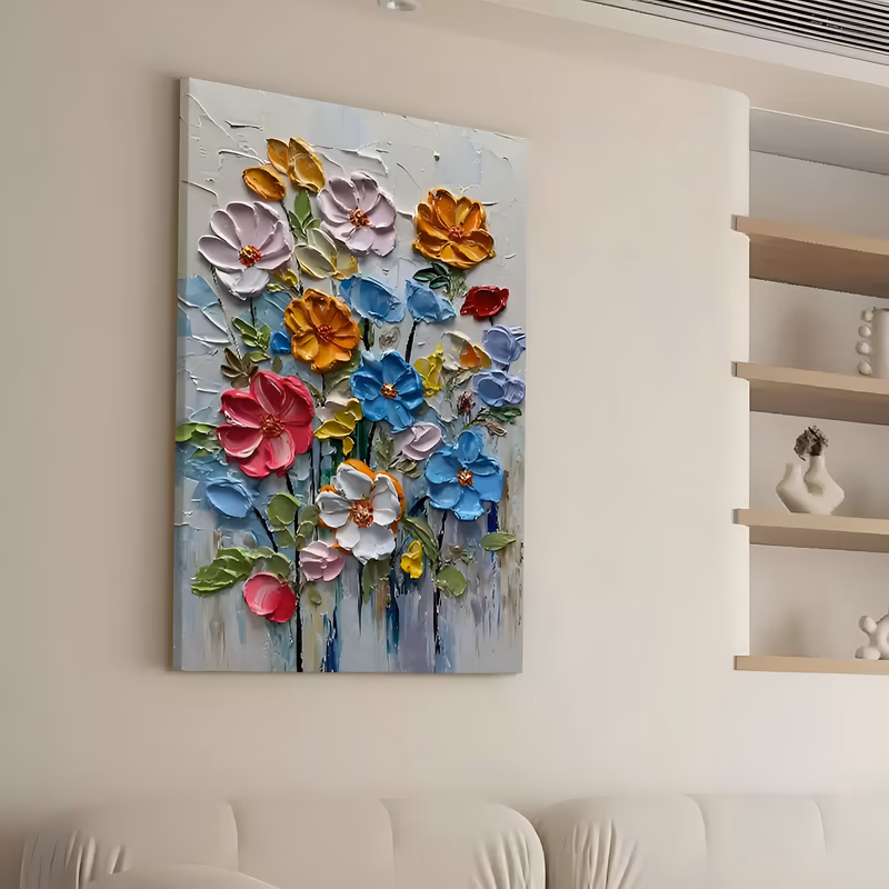 a large vertical sculpted flower painting of wildflowers on thin black stems, pink, sky blue, orange, yellow and white blooms with raised gold centers spread over a white textured ground, in thick relief