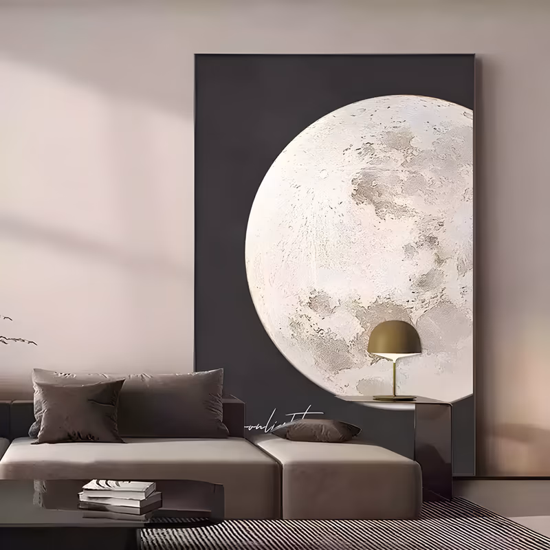 a large vertical minimalist painting of a full moon in pale gray and white, cropped by the right edge of a matte black field, its craters built up as thick raised plaster relief