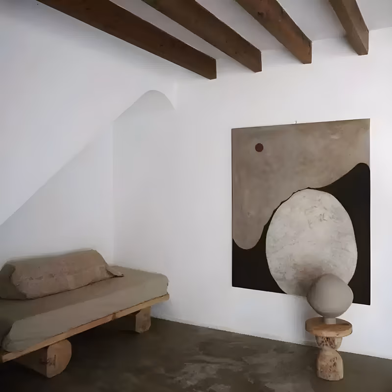 a large vertical wabi-sabi painting of a pale beige oval stone form set low against a mottled brown field and a black slope on the right, with a small rust-red sun dot at the upper left, in flat dry pigment