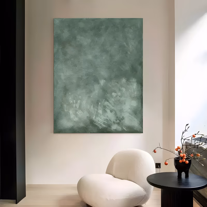 a large vertical minimalist painting of a mottled sage green plaster field with soft white brush marks low in the center of the frame, worked in matte troweled impasto with a chalky surface