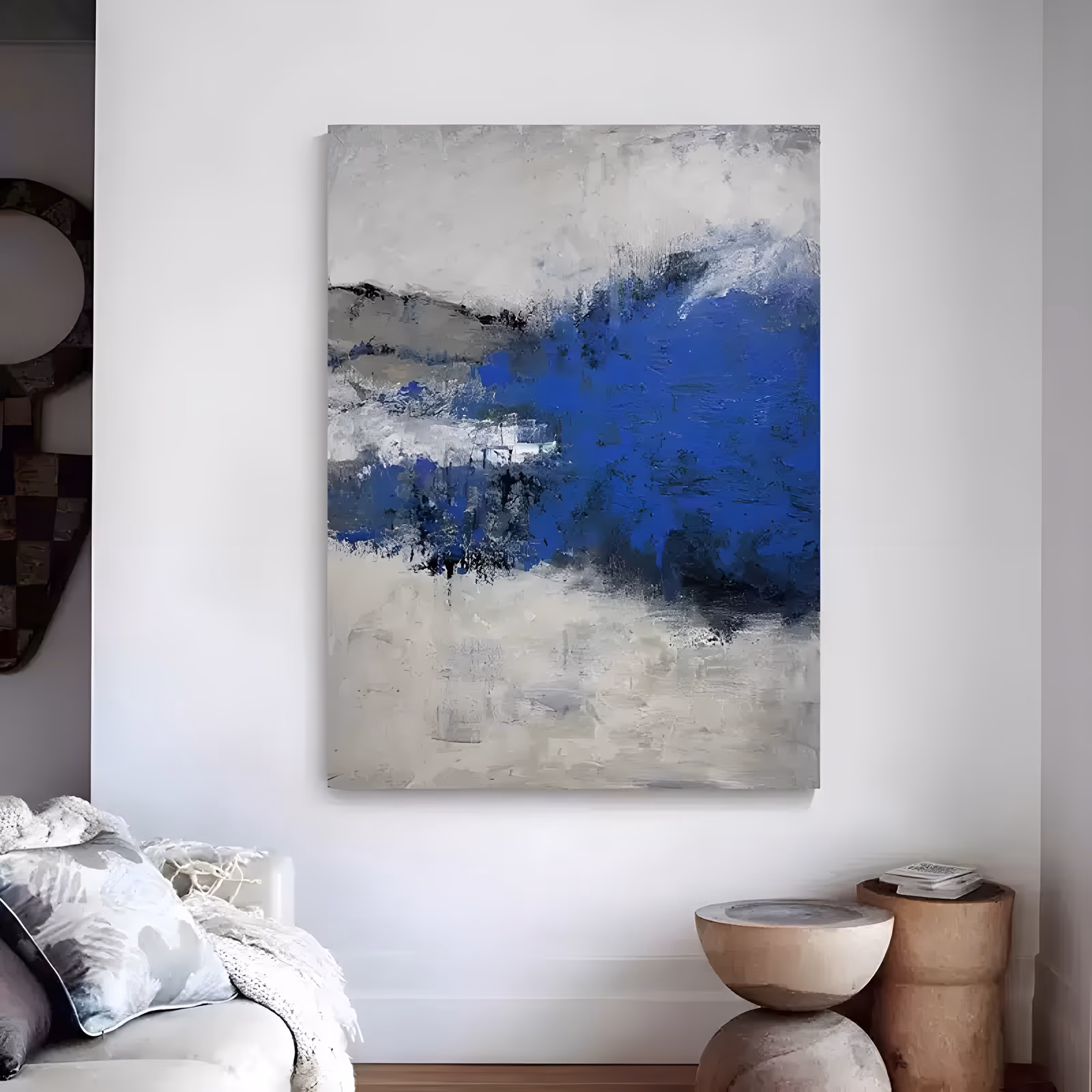 a large vertical abstract painting of a dense cobalt blue mass sitting right of center over a scraped gray and cream ground, with black flecks along its lower edge, in thick palette-knife oil
