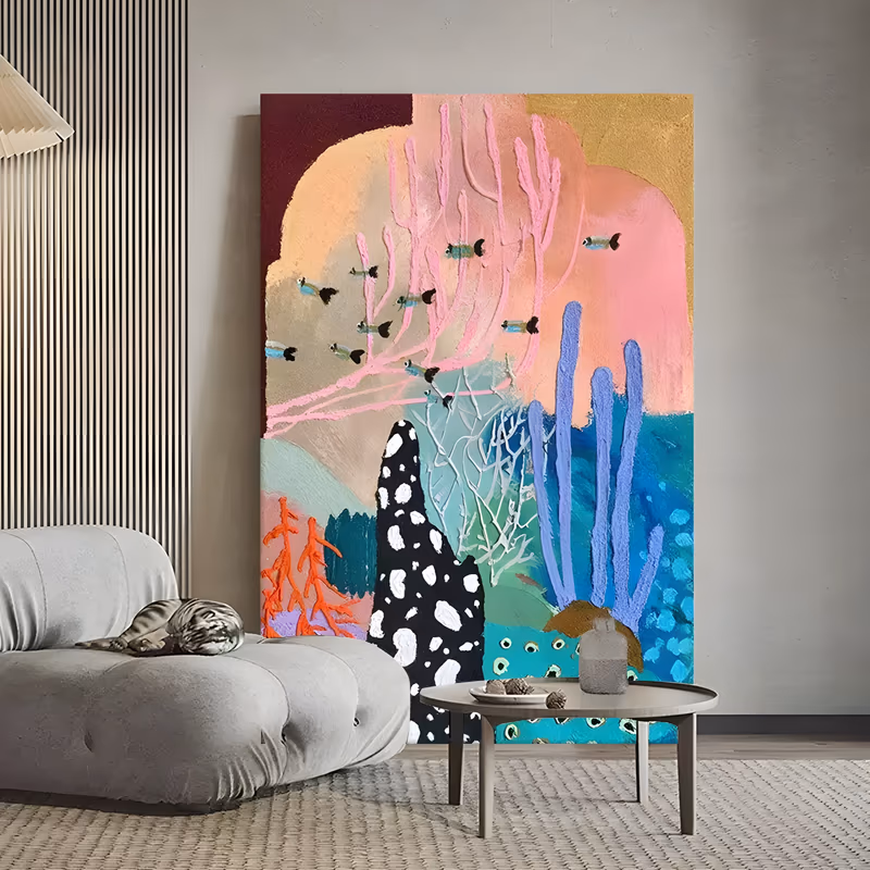 a large vertical textured painting of a pastel coral reef with pink branching coral above, periwinkle tube sponges and a black white-spotted rock below, and small teal fish darting between them, in raised plaster relief