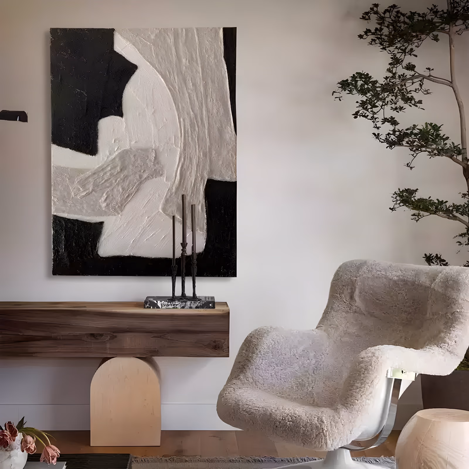 a large vertical black and white relief painting of thick cream plaster forms curving down the center and right of the frame over a flat black field, in sculpted plaster with raised edges