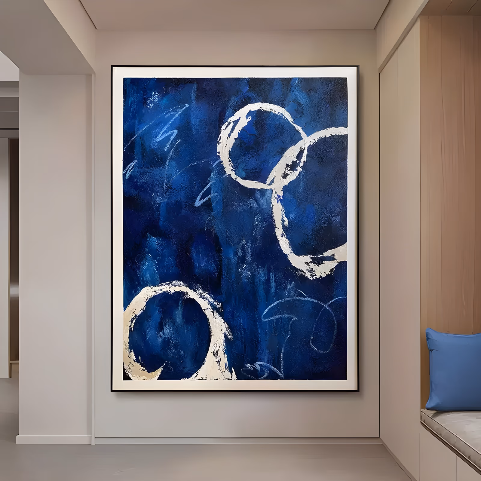 a large vertical abstract painting of three cream-white rings looped over a deep navy blue ground, with faint pale scribbles between them, in thick impasto paint with visible knife edges