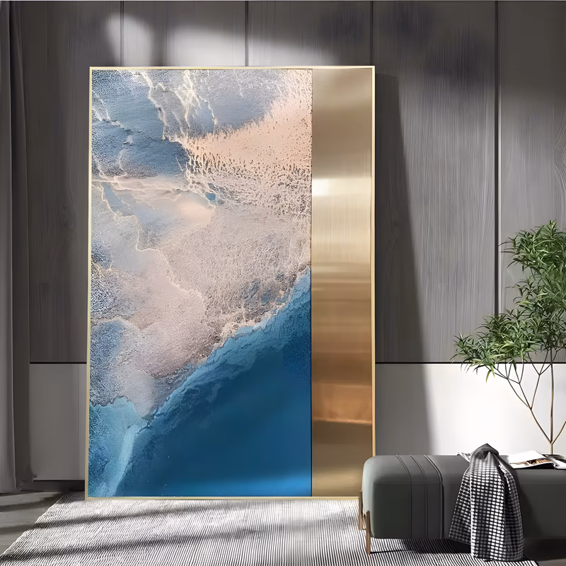 a large vertical abstract painting of an aerial coastline in deep teal blue, pale pink and cream, with heavy pitted texture along the shoreline and a smooth brushed gold panel down the right edge, in sculpted acrylic
