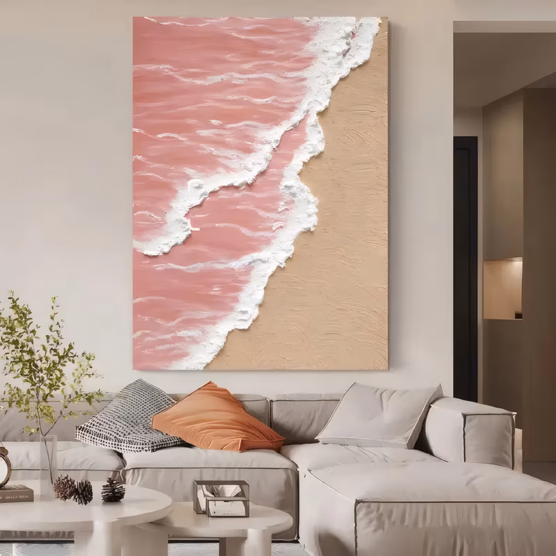 a large vertical relief painting of a pink sea meeting beige sand on a diagonal, with a sculpted white foam line raised along the water's edge, the sand combed into fine ridges of thick plaster