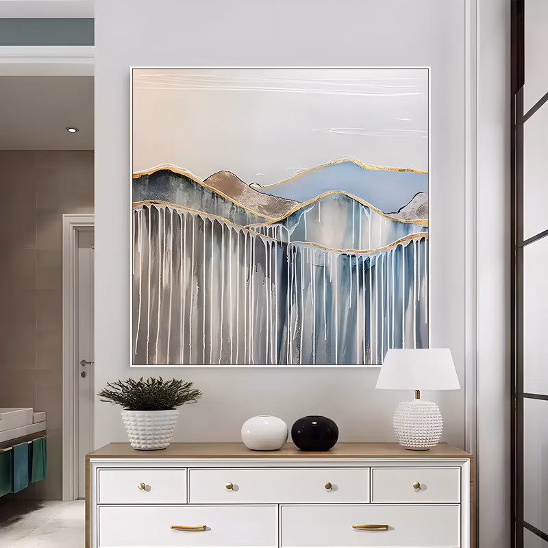 a large square abstract painting of stylized blue and gray mountain ridges outlined in gold, with long white paint drips running down from the peaks over a pale cream sky, in thick palette-knife acrylic