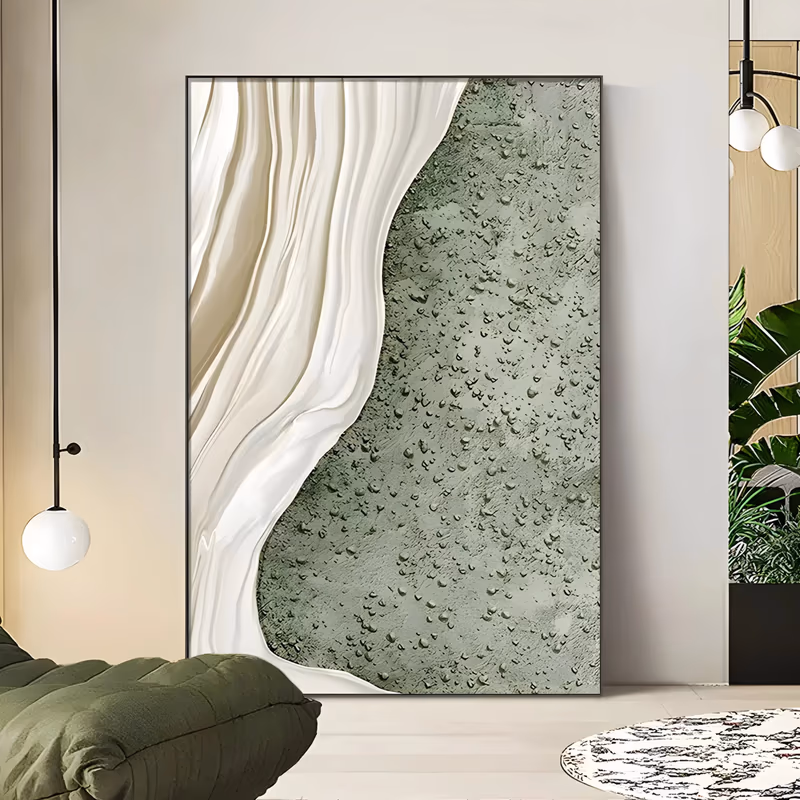 a large vertical relief painting of a cream-white wave of ridged folds curving down the left side against a sage green ground pocked with raised pebbles, like foam meeting wet sand, in sculpted plaster