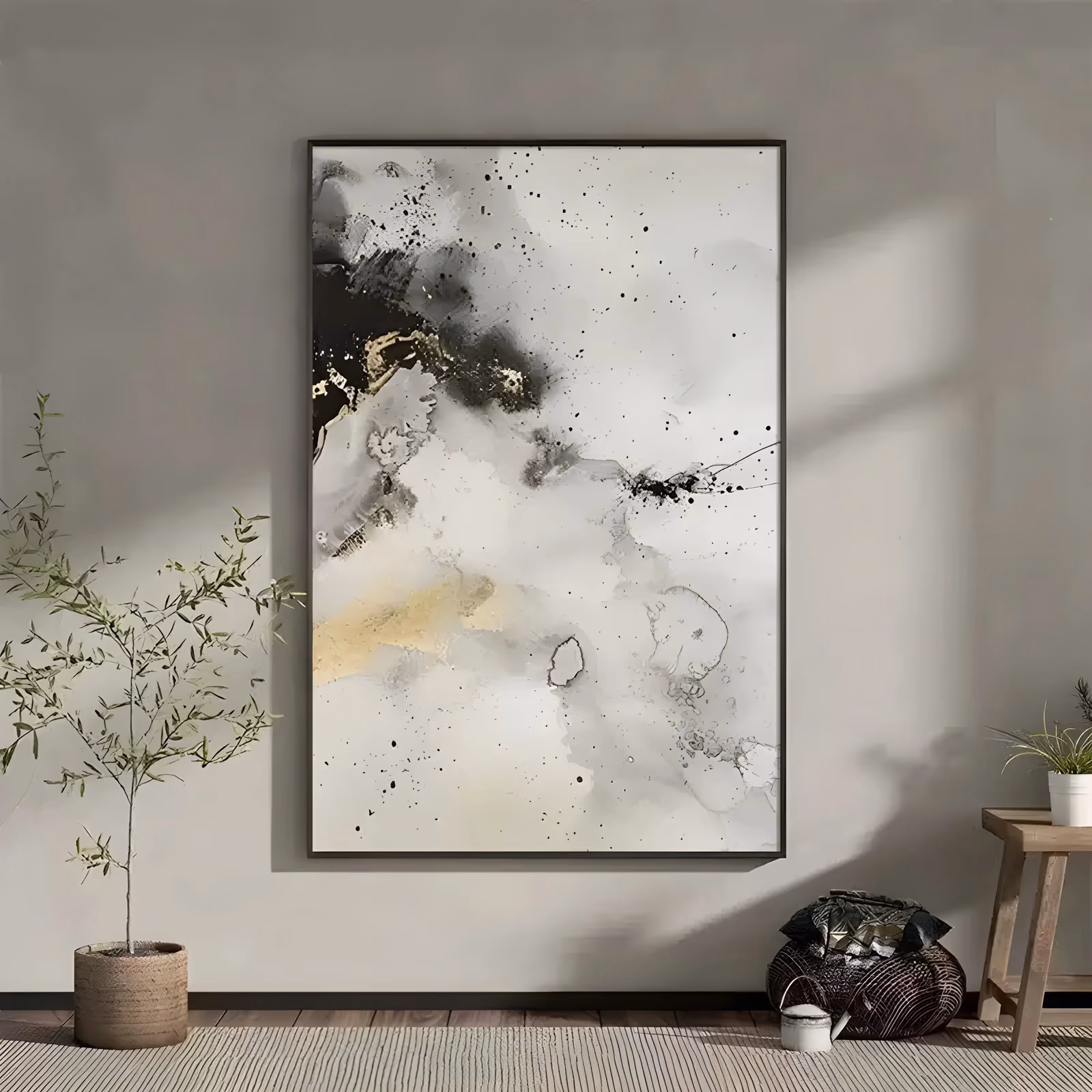 a large vertical abstract painting of pale gray ink wash clouds with black splatter falling near the top left, a cream and gold patch below it, and wide white space at the lower right, in thin flowing acrylic