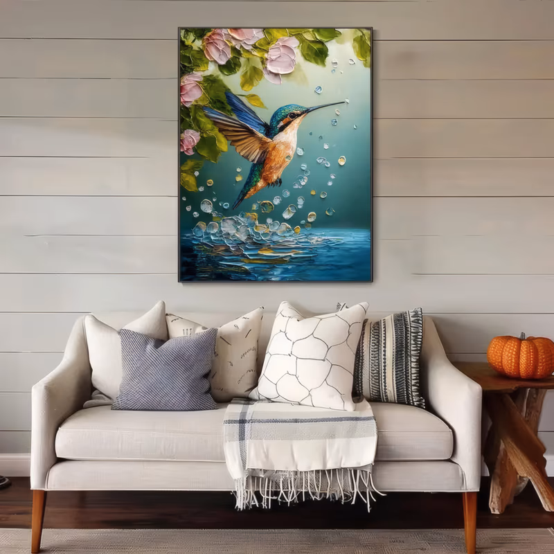 a large vertical wildlife painting of a teal and orange hummingbird hovering just above blue water, surrounded by round droplets, with pink blossoms and green leaves hanging in the top corners, in thick impasto