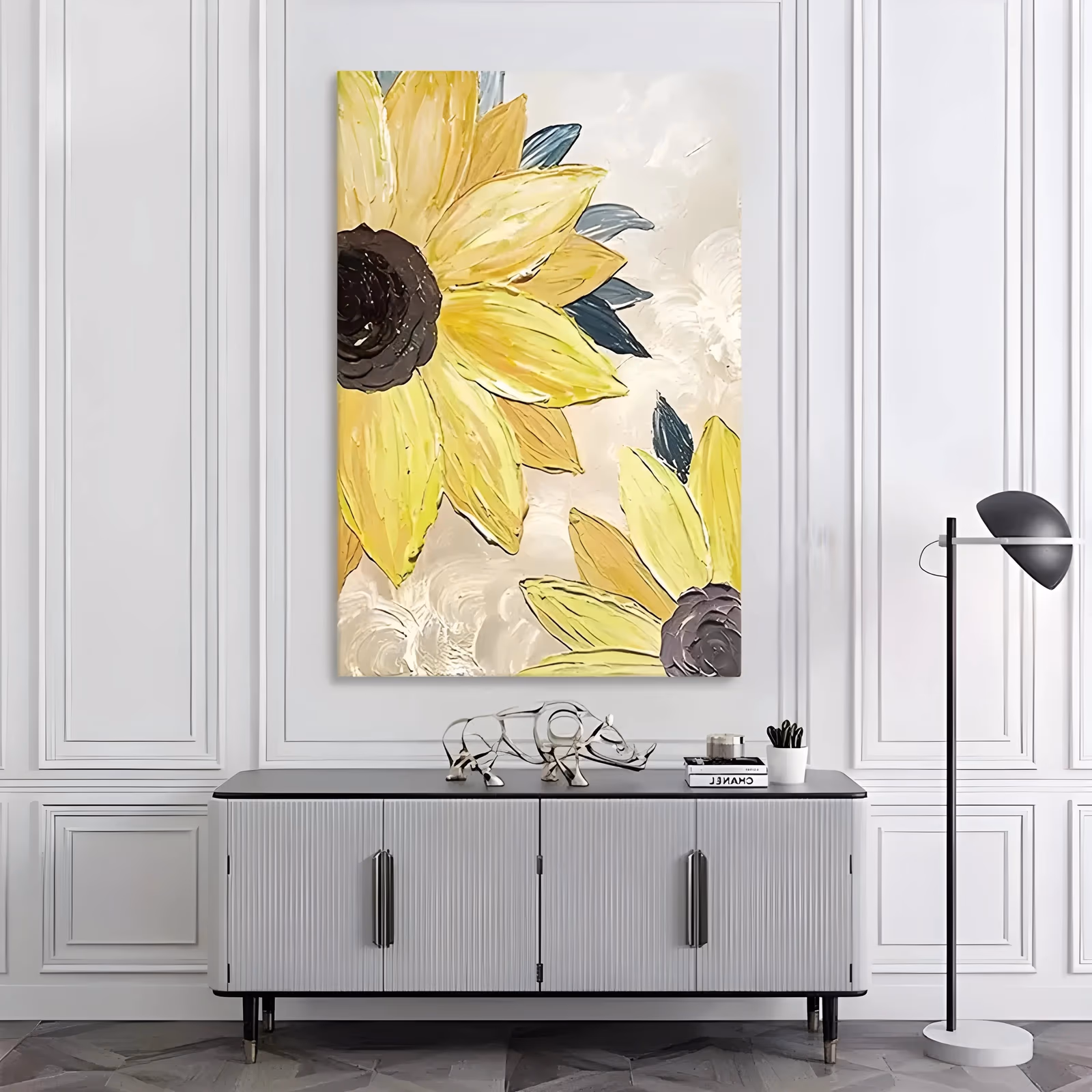 a tall vertical impasto floral painting showing two oversized pale yellow sunflowers in close-up at the left edge, their dark brown centers ringed by thick knife-laid petals, with slate blue leaves on a cream ground
