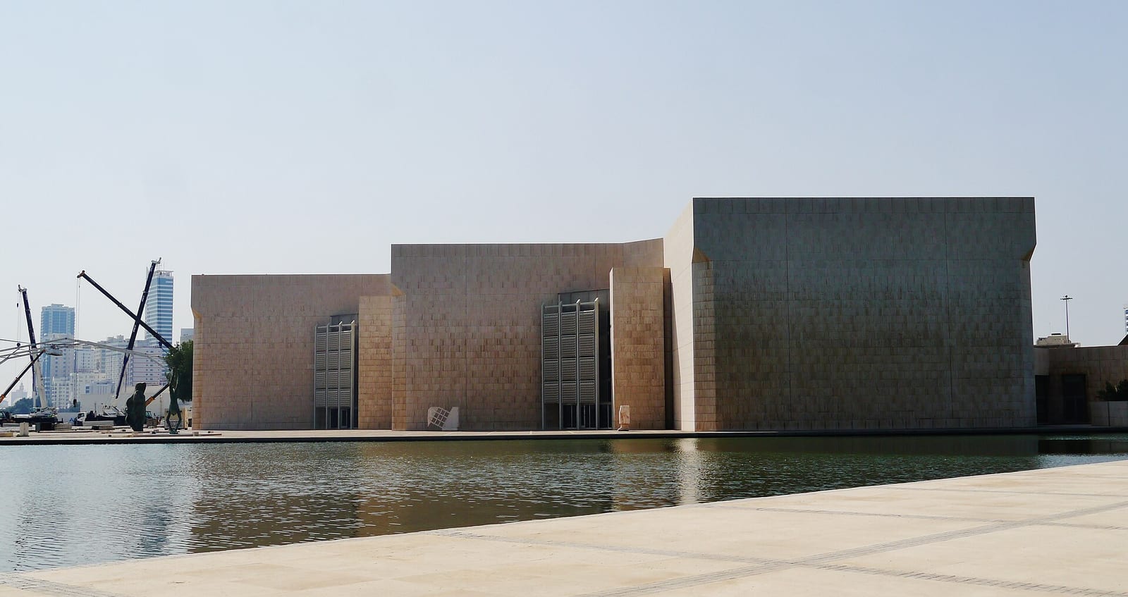 The travertine-clad Bahrain National Museum on the Manama waterfront, with its low geometric blocks and reflecting pool.