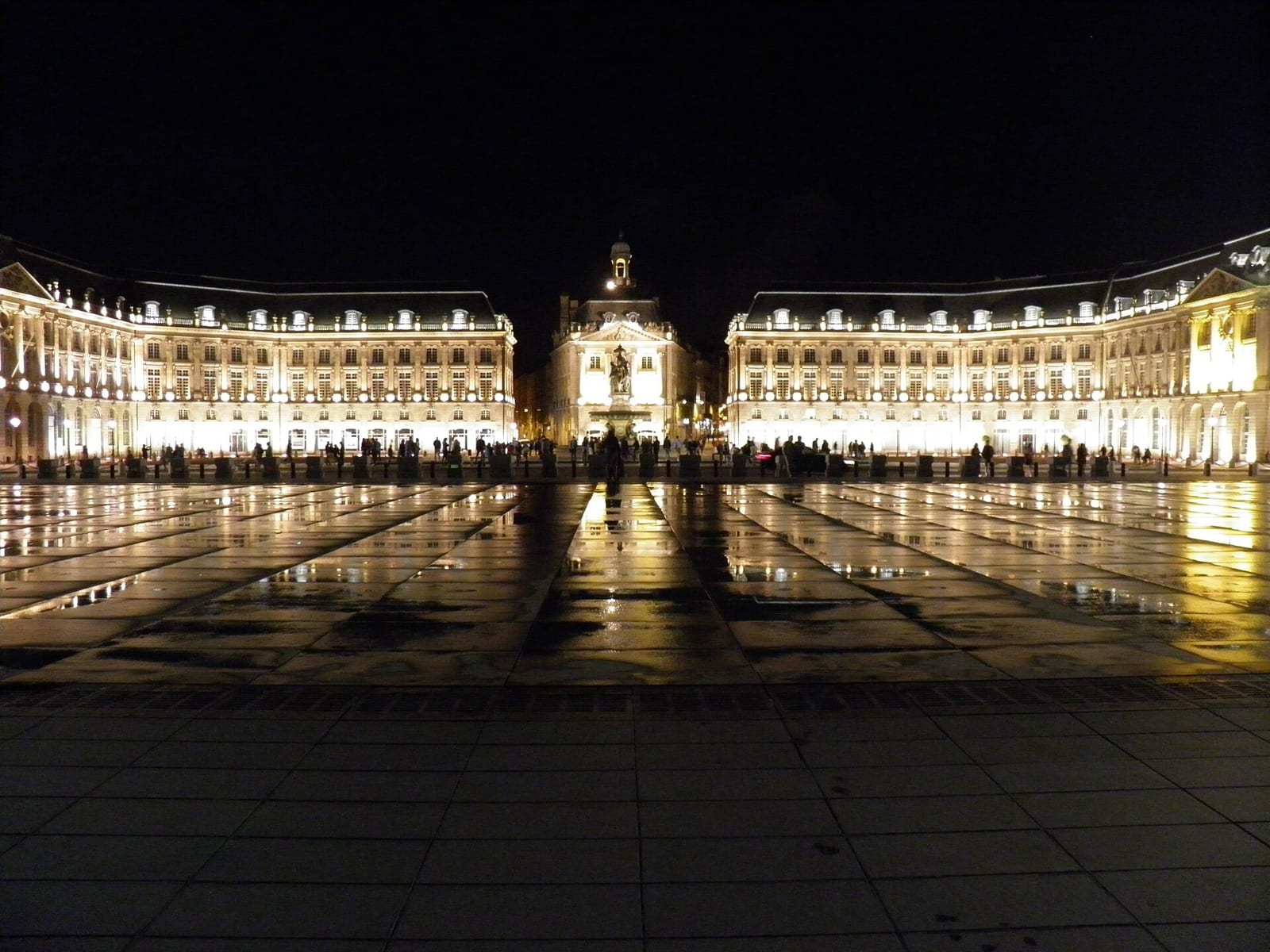 Place de la Bourse in Bordeaux at night, its 18th-century facades reflected in the flooded miroir d’eau.