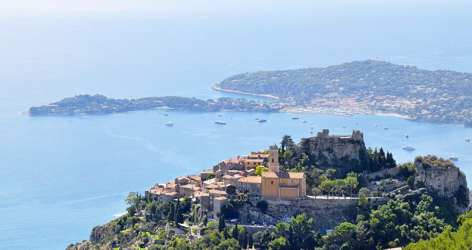 The hill village of Èze above the Mediterranean with the Cap Ferrat peninsula and the bay in the background.