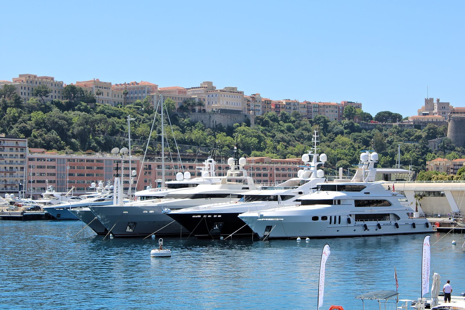 Yachts moored in Port Hercule, Monaco, with the apartment blocks of the Rock and Monaco-Ville rising behind.