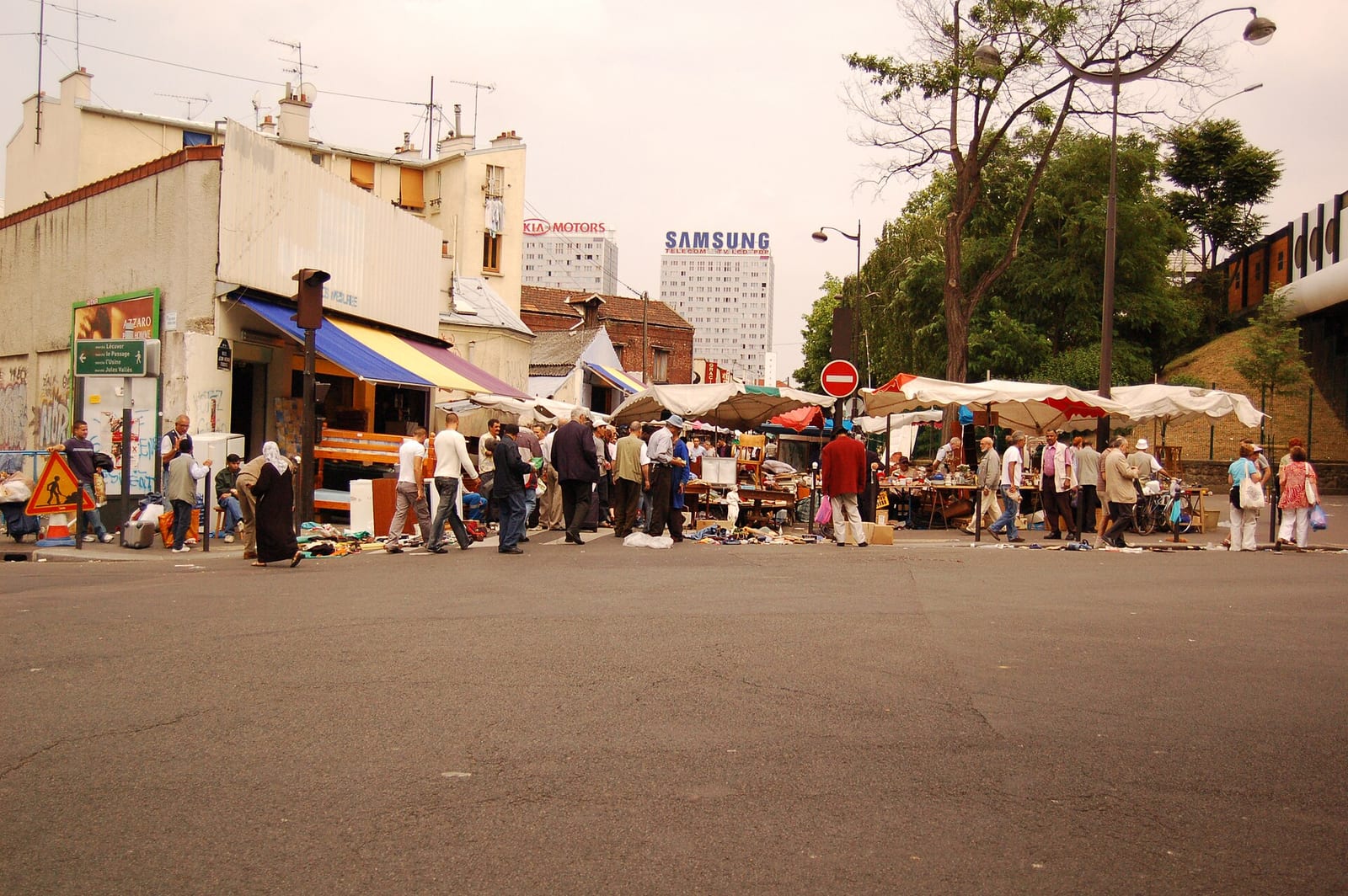 Stallholders and shoppers at the Saint-Ouen flea market on the northern edge of Paris on a sunny day.