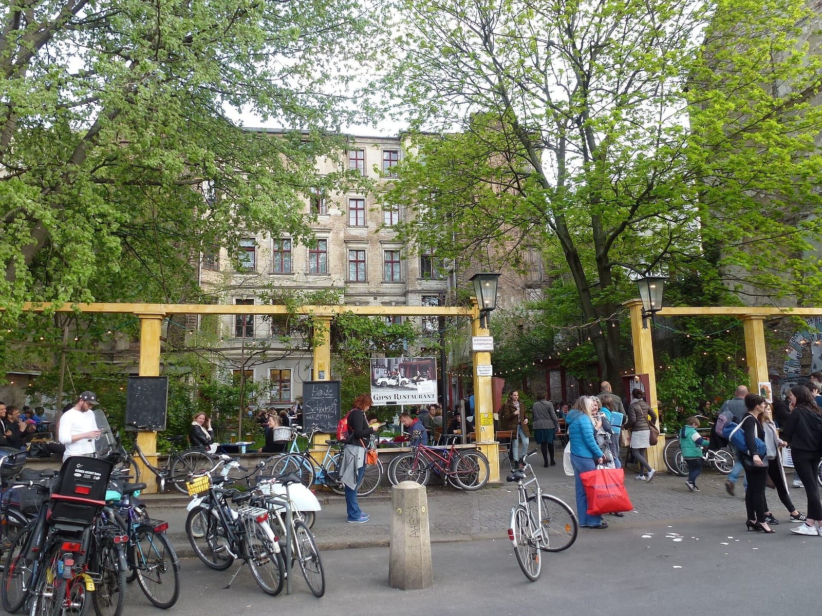 Crowds and bicycles outside Clärchens Ballhaus on Berlin's Auguststraße during Gallery Weekend