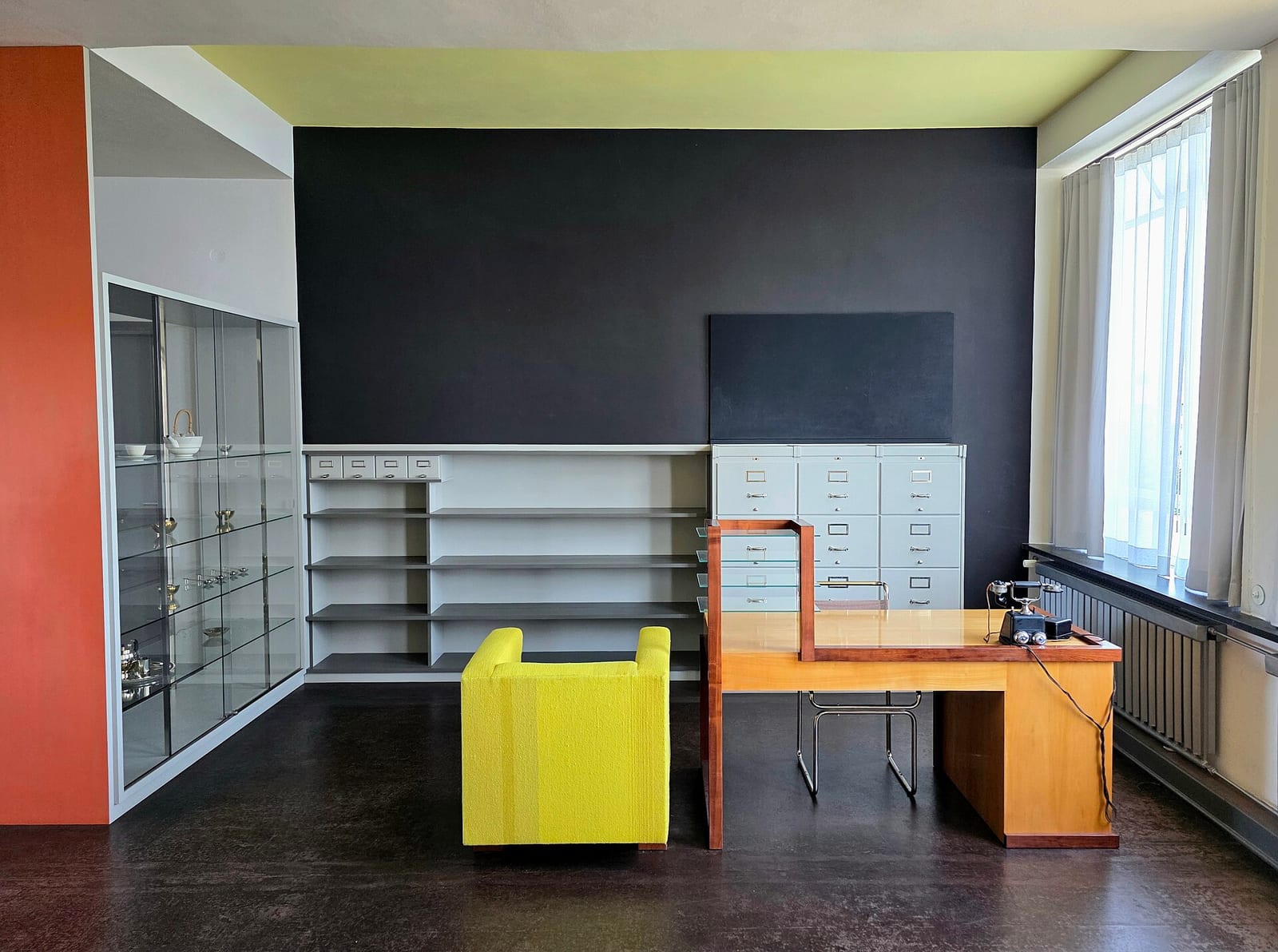 Reconstructed director's office in the Bauhaus building in Dessau with yellow armchair and built-in shelving