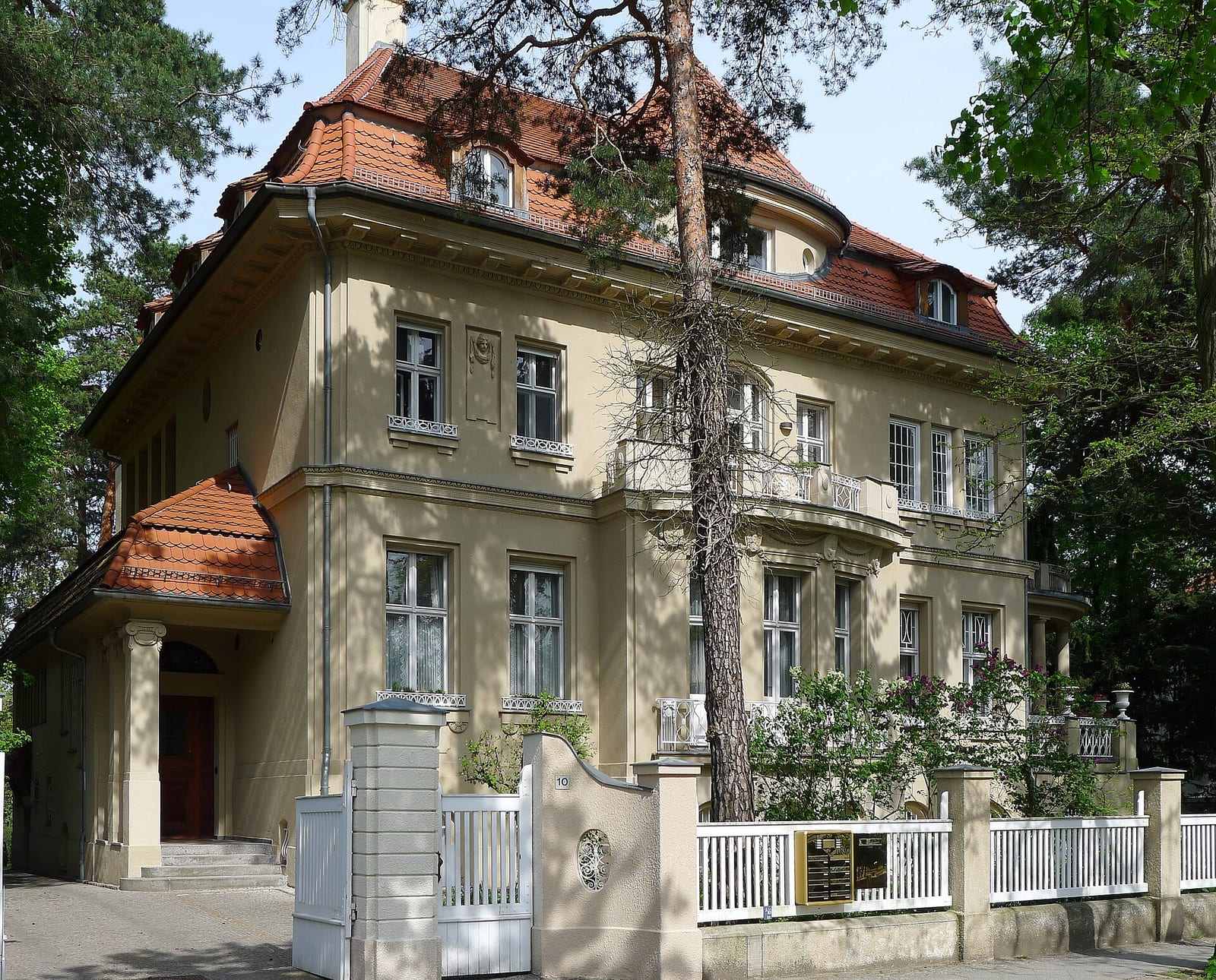 Historic stucco villa behind a garden wall on Delbrückstraße in Berlin-Grunewald
