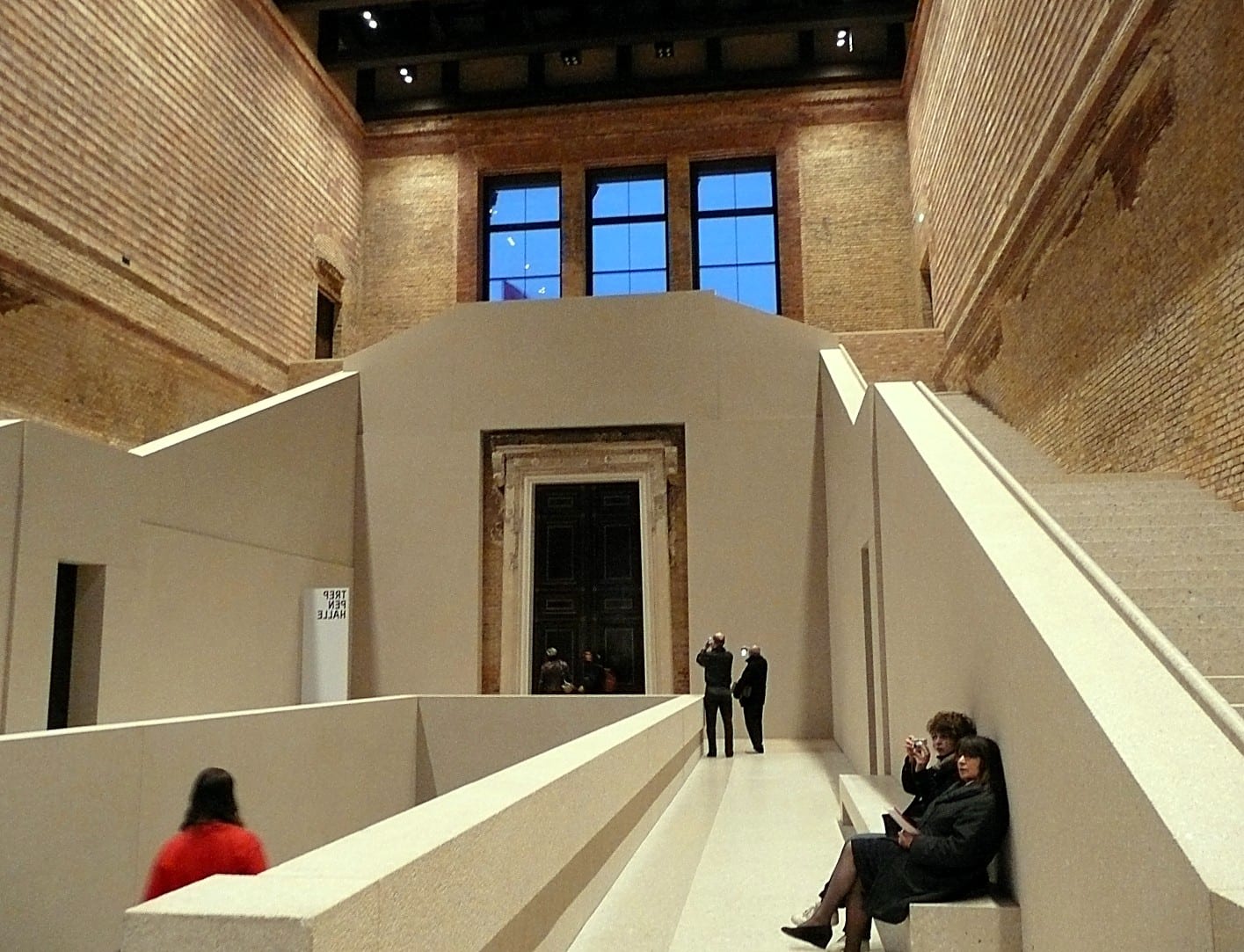 Restored brick stair hall of the Neues Museum in Berlin with a modern concrete staircase
