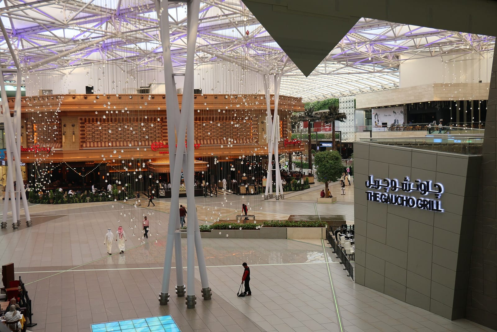 Morning view along the Grand Avenue inside The Avenues mall, Kuwait, a glass-roofed street lined with two-storey stone shopfronts, August 2015.