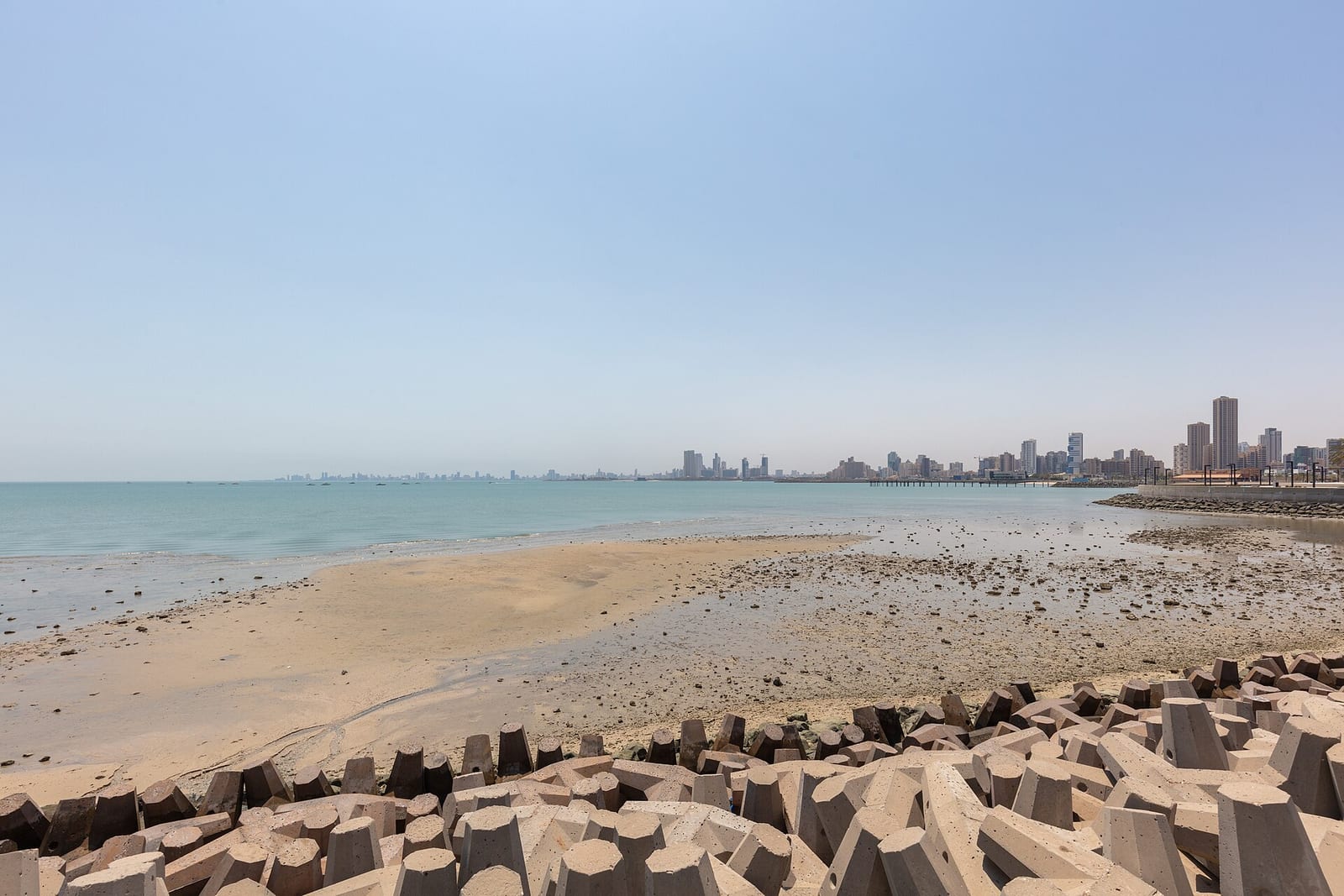 Dasman Beach on Kuwait City's Gulf coast with pale sand, shallow turquoise water and towers on the horizon, August 2024.