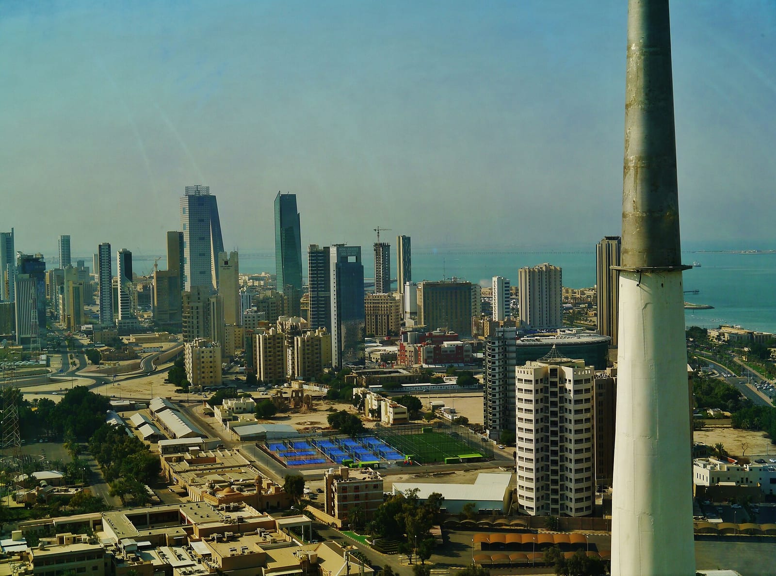 View from the Kuwait Towers observation sphere over Kuwait City's low white residential blocks toward the downtown tower cluster, December 2022.