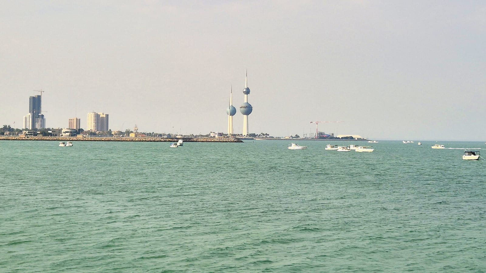 The three Kuwait Towers with their blue-green tiled spheres seen from the Gulf coast under a clear sky, January 2025.