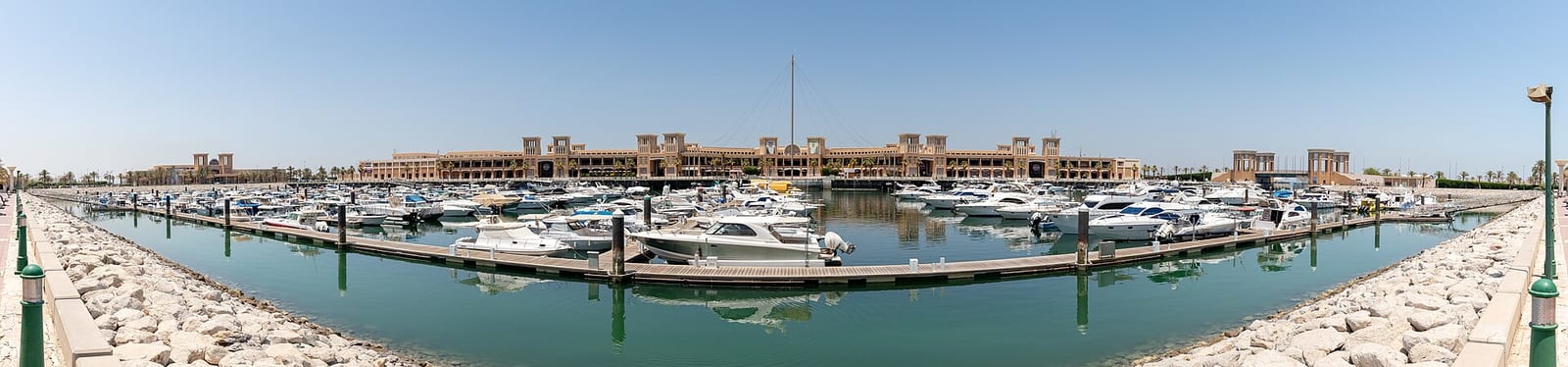 Stitched panorama, about four times wider than high, of the Souq Sharq marina and Kuwait City skyline across the water, August 2024.