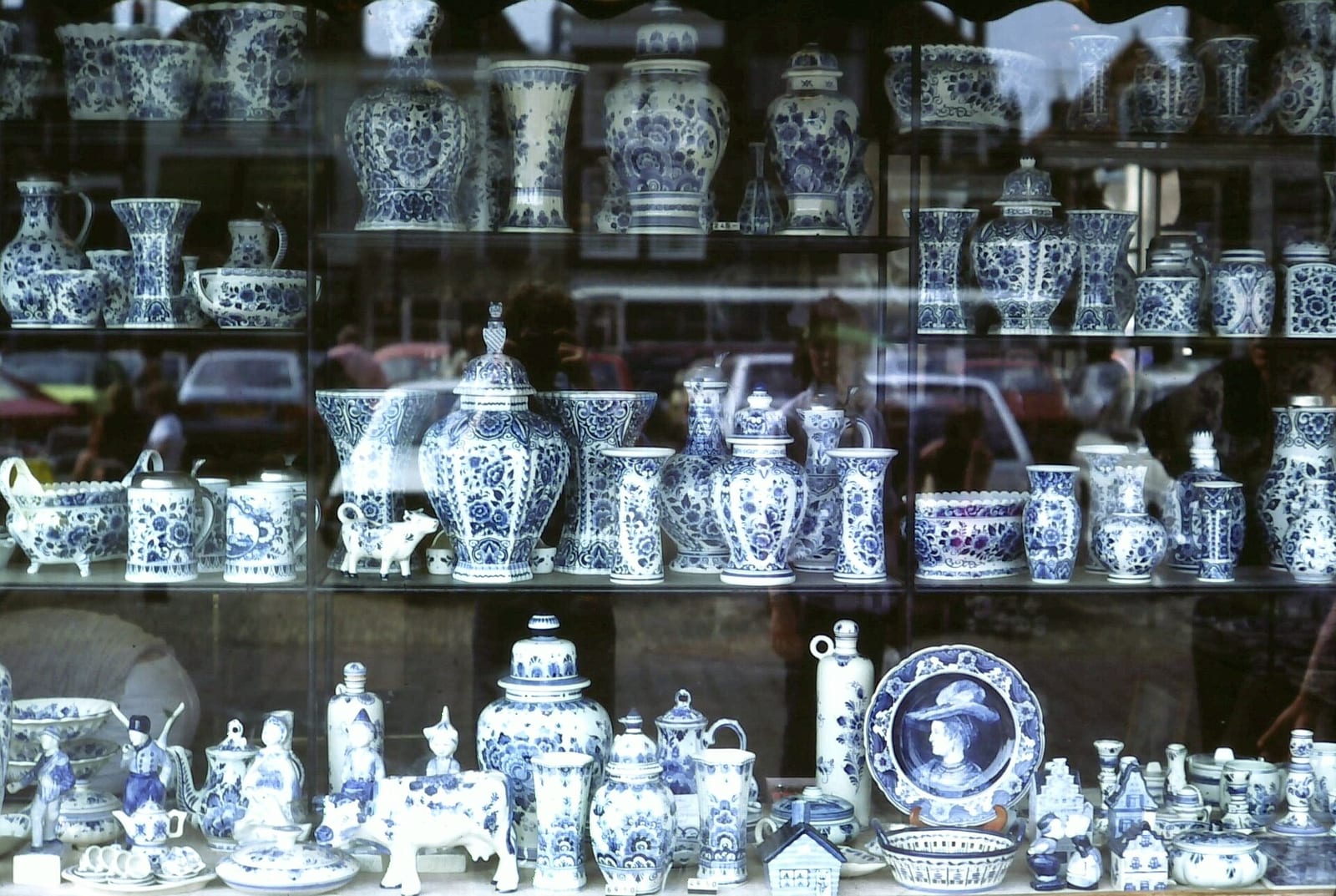 A shop window in Delft crowded with blue-and-white Delftware vases, plates, jugs and tiles.